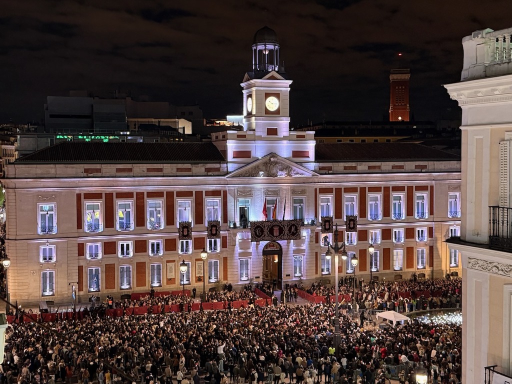 Photo of a crowd in Puerto del Sol, Madrid, Spain, watching an evening Holy Week procession