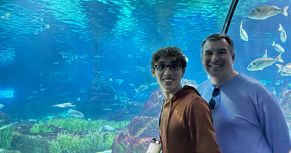 Photo of parent and teenager on moving walkway through Barcelona Aquarium exhibit