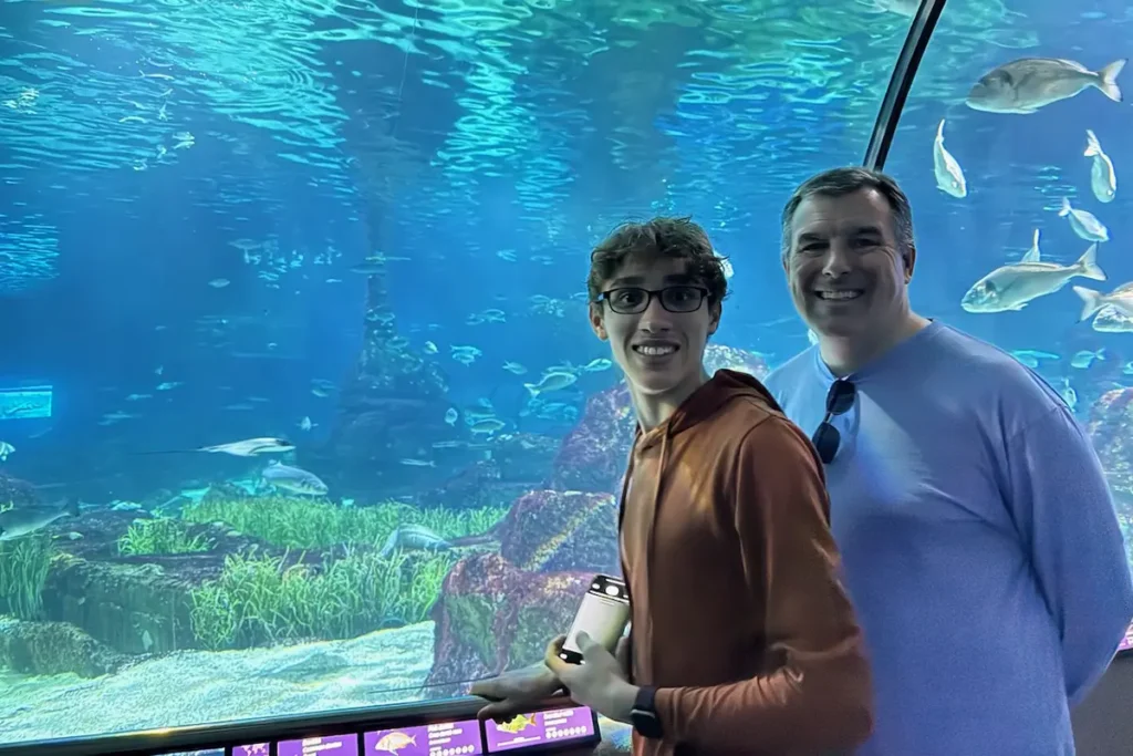 Photo of parent and teenager on moving walkway through Barcelona Aquarium exhibit