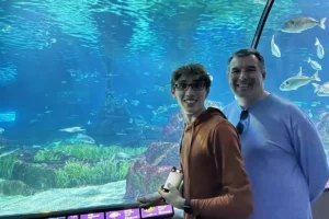 Photo of parent and teenager on moving walkway through Barcelona Aquarium exhibit