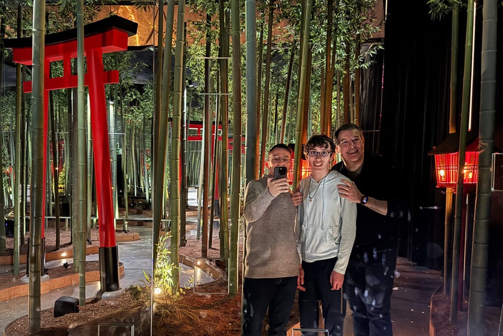 Family standing in a bamboo forest art exhibit
