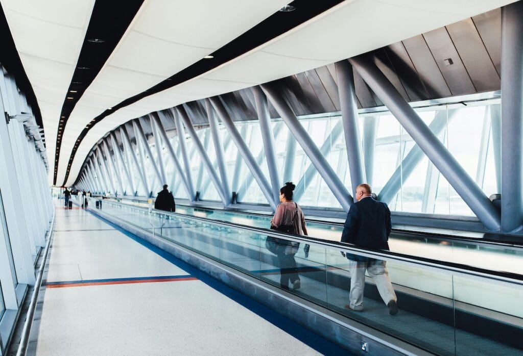 Photo of airport hallway with people on a moving walkway
