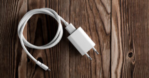 A cell phone charging cable is plugged into a European power adaptor